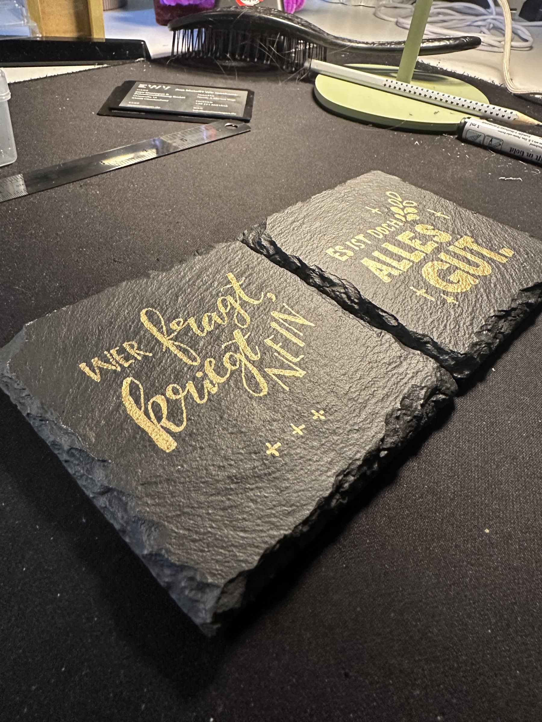 Zwei fertige Schiefer-Untersetzer mit goldenem Handlettering